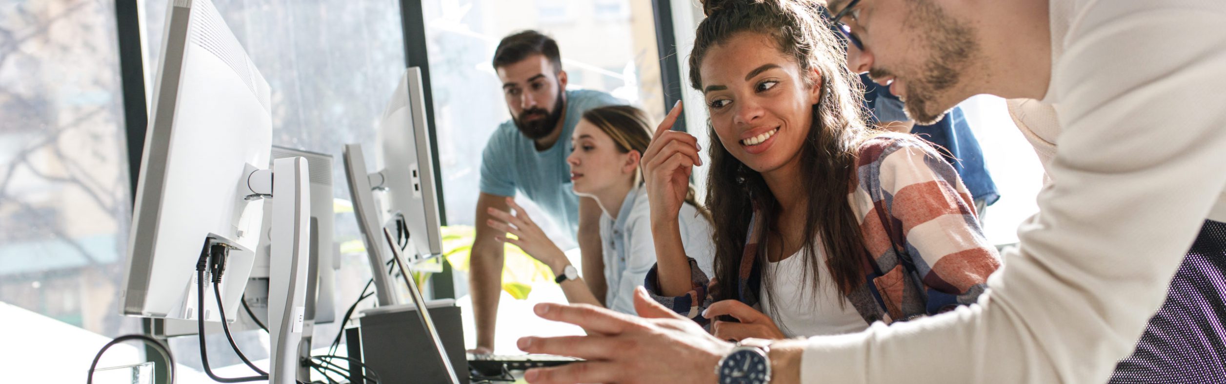 Group of team workers and programmers starting a new project.Senior programmer giving help to beginner. Group of team workers and programmers starting a new project.Senior programmer giving help to beginner.